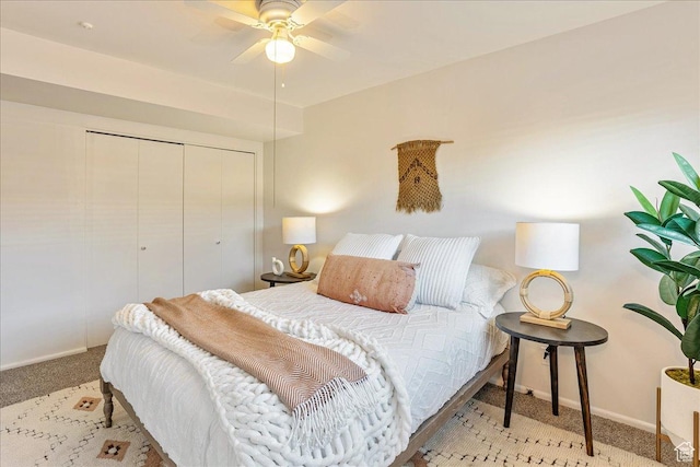 carpeted bedroom with a closet, ceiling fan, and baseboards