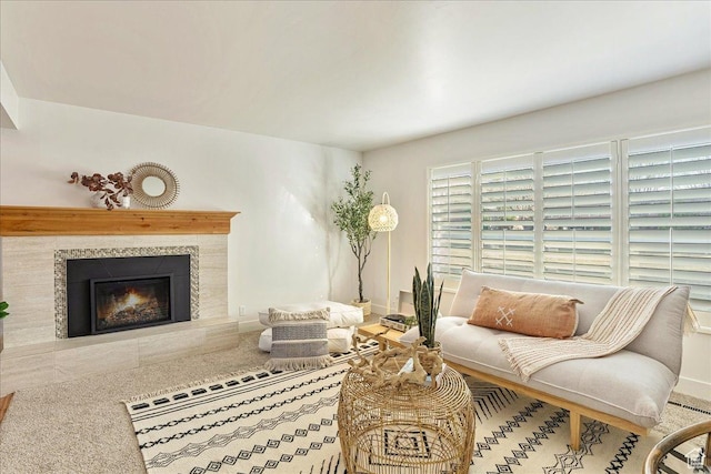 living room featuring a tile fireplace and baseboards