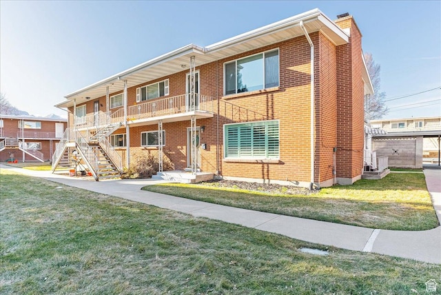 townhome / multi-family property with a front lawn, brick siding, and a chimney
