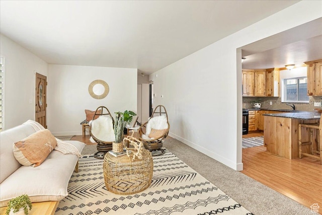living area featuring baseboards and light wood-type flooring