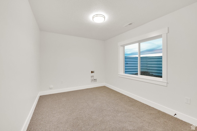 unfurnished room featuring visible vents, baseboards, carpet floors, and a textured ceiling