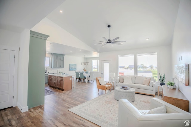 living room featuring lofted ceiling, a ceiling fan, wood finished floors, and recessed lighting