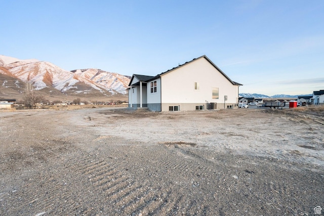 view of side of home featuring central AC unit and a mountain view