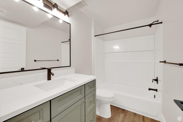 full bathroom featuring wood finished floors, vanity,  shower combination, and toilet