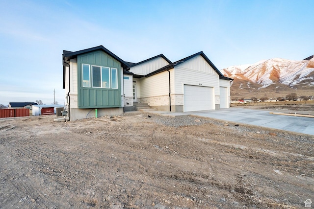 view of front of house with concrete driveway, a mountain view, an attached garage, and board and batten siding