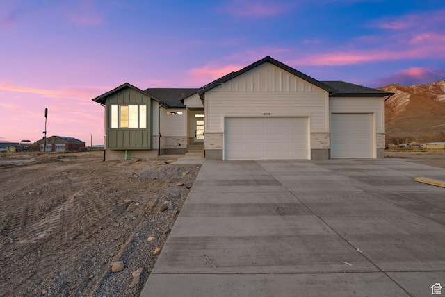 ranch-style home with board and batten siding, an attached garage, and driveway