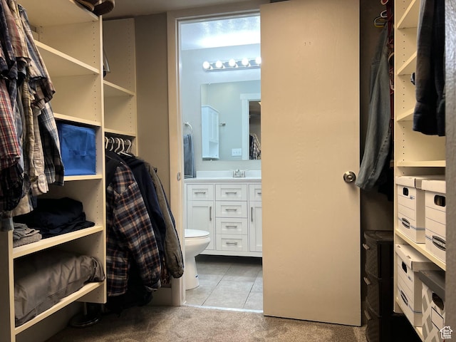 walk in closet with tile patterned floors and carpet flooring