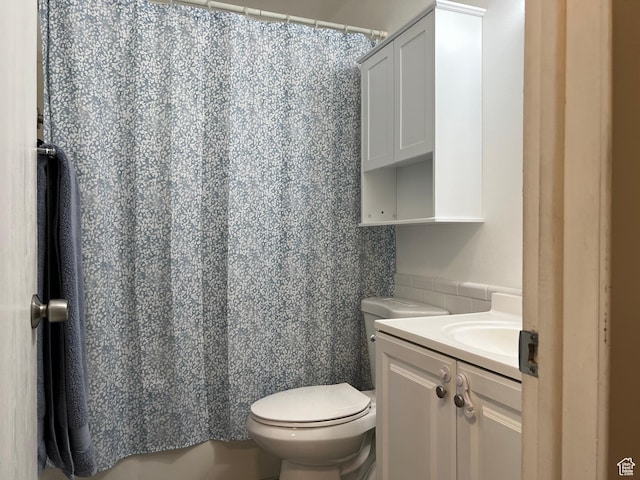 full bath with toilet, a shower with shower curtain, and vanity