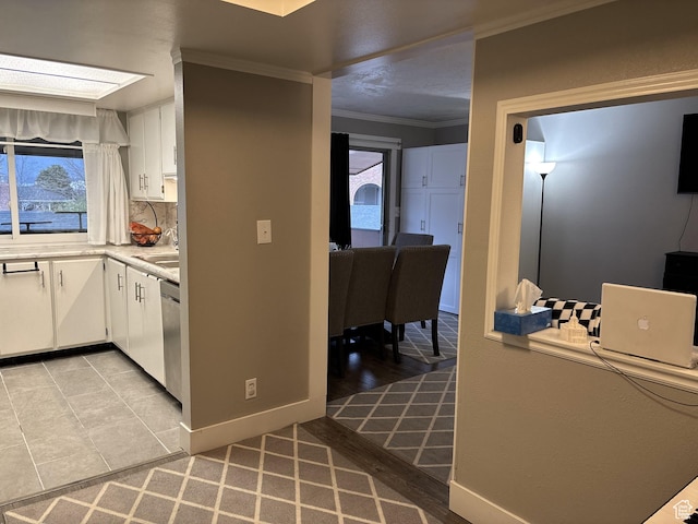 kitchen featuring ornamental molding, backsplash, white cabinets, and dishwasher