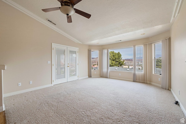 unfurnished room featuring carpet, visible vents, vaulted ceiling, french doors, and a textured ceiling