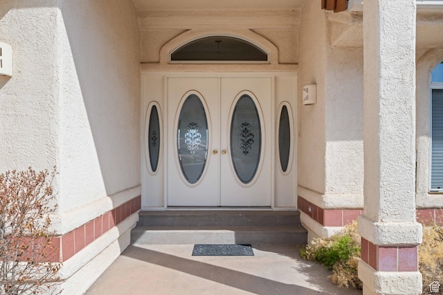 view of exterior entry featuring stucco siding