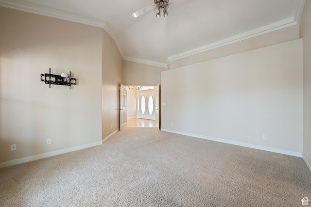 spare room featuring carpet floors, crown molding, baseboards, ceiling fan, and vaulted ceiling