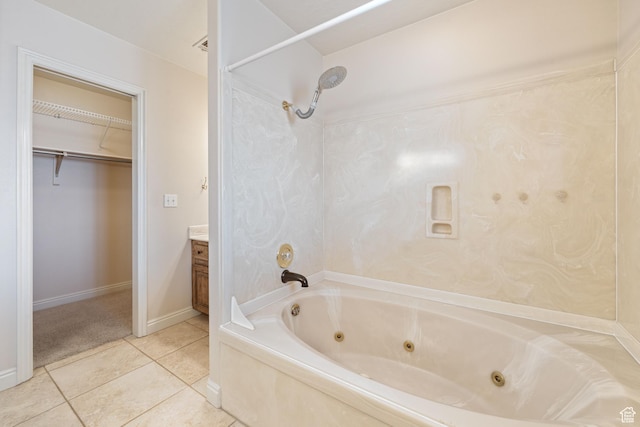 bathroom with tile patterned floors, a walk in closet, a combined bath / shower with jetted tub, baseboards, and vanity