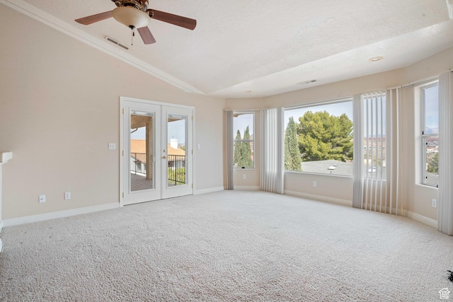 carpeted empty room featuring lofted ceiling, plenty of natural light, a ceiling fan, and visible vents