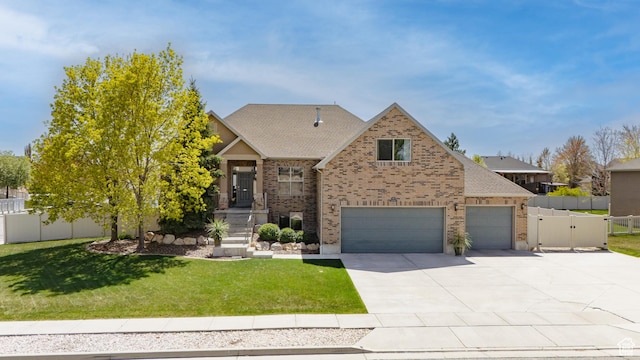 craftsman-style home with brick siding, fence, a front lawn, and driveway