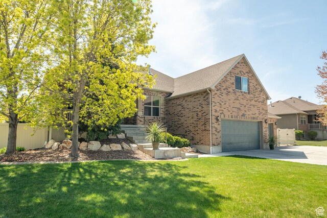 2581 W 2675 N, Farr West, UT 84404 - view of front of home featuring driveway, a front yard, brick siding, and a garage