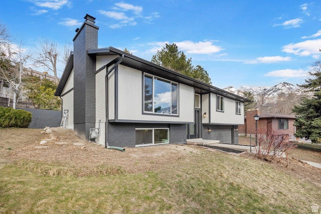 2605 E Portsmouth Ave S, Cottonwood Heights, UT 84121 - back of house with a mountain view, an attached garage, a chimney, and driveway