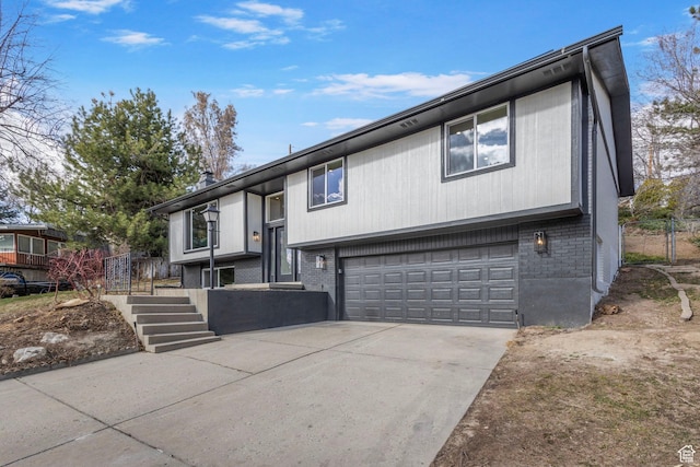2605 E Portsmouth Ave S, Cottonwood Heights, UT 84121 - split foyer home featuring stairway, brick siding, a garage, and driveway