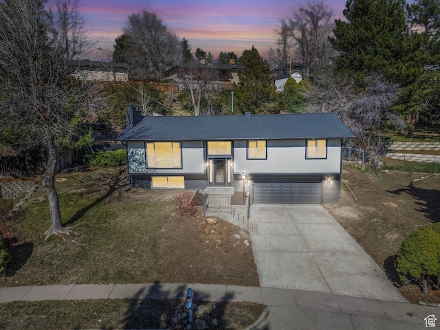 view of front of property with driveway, an attached garage, and a front lawn