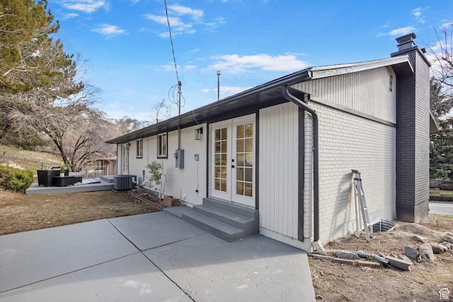 2605 E Portsmouth Ave S, Cottonwood Heights, UT 84121 - back of property with entry steps, a patio, central AC, french doors, and a chimney