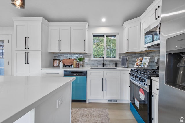 2605 E Portsmouth Ave S, Cottonwood Heights, UT 84121 - kitchen featuring appliances with stainless steel finishes, white cabinetry, light countertops, and a sink