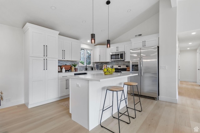 2605 E Portsmouth Ave S, Cottonwood Heights, UT 84121 - kitchen with a kitchen island, light wood-type flooring, appliances with stainless steel finishes, a kitchen breakfast bar, and white cabinetry