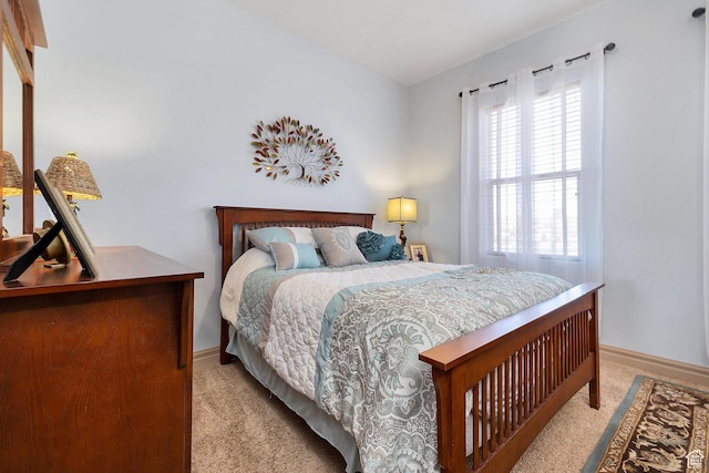 bedroom with light colored carpet and baseboards