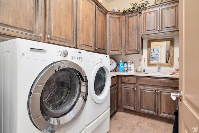 laundry room with a sink, cabinet space, light tile patterned floors, and washer and clothes dryer