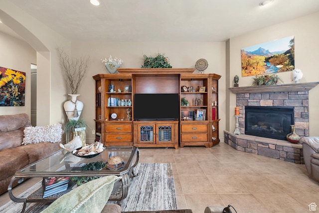 living area with light tile patterned floors, a fireplace, and arched walkways