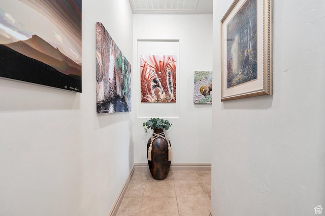 corridor featuring tile patterned flooring, baseboards, and visible vents