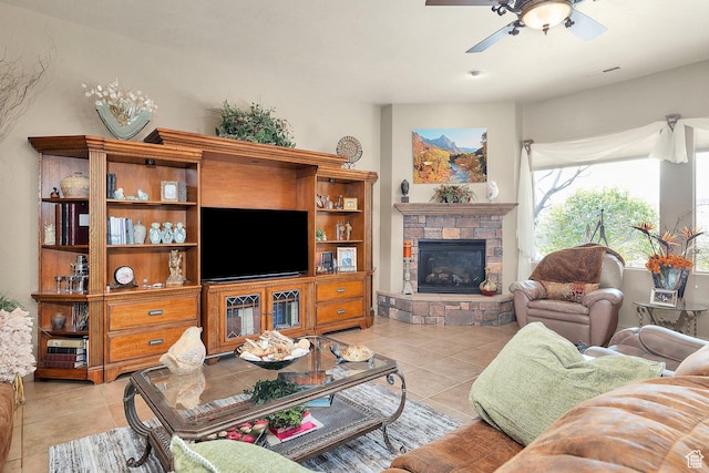 living area with light tile patterned flooring, a fireplace, visible vents, and ceiling fan