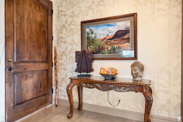 interior space with light tile patterned floors, wallpapered walls, and baseboards