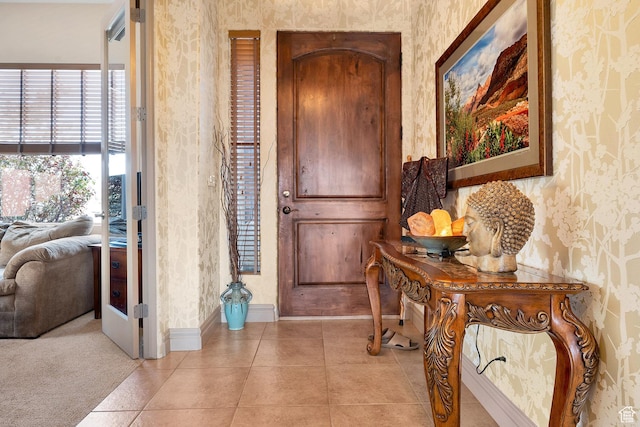 entrance foyer with wallpapered walls, light tile patterned flooring, and baseboards