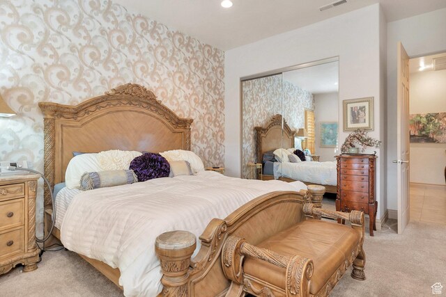 bedroom with recessed lighting, a closet, light colored carpet, and visible vents