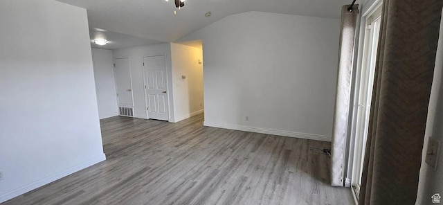 8084 N N Ridge Loop Unit F12, Eagle Mountain, UT 84005 - spare room featuring visible vents, lofted ceiling, baseboards, and wood finished floors