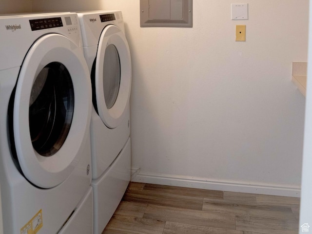 8084 N N Ridge Loop Unit F12, Eagle Mountain, UT 84005 - washroom with light wood-style flooring, electric panel, baseboards, laundry area, and washing machine and clothes dryer