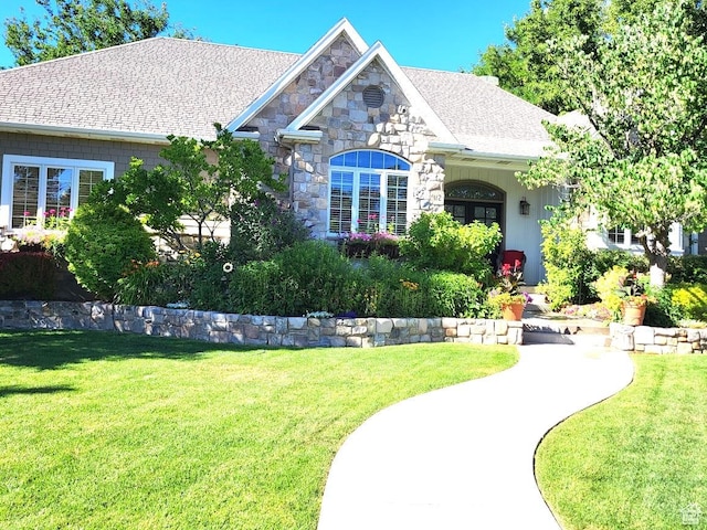 view of front of home with a front lawn and stone siding