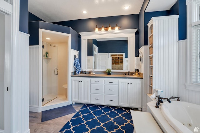 bathroom with a sink, a whirlpool tub, double vanity, and a shower stall