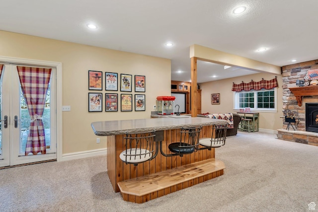 kitchen with recessed lighting, a breakfast bar area, light colored carpet, and open floor plan