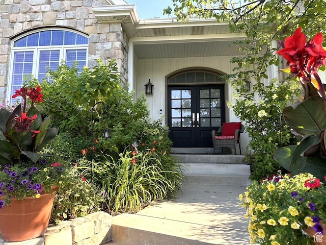 property entrance featuring stone siding and french doors