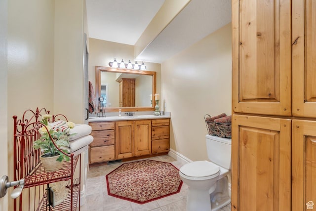 bathroom featuring vanity, tile patterned floors, toilet, and baseboards