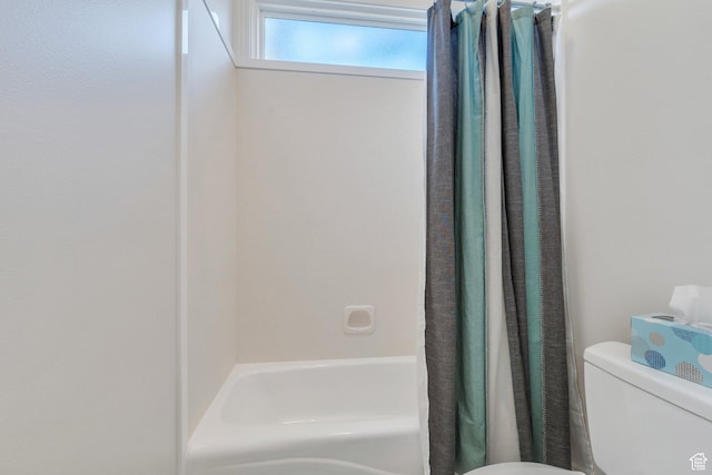 bathroom with toilet and shower / tub combo with curtain