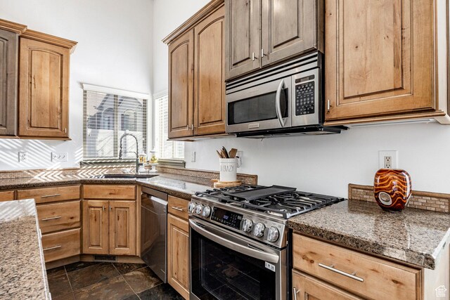 2652 E 6500 S, Uintah, UT 84403 - kitchen with stainless steel appliances, a sink, dark stone finish floors, and light stone counters