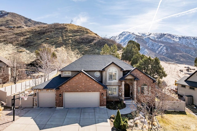 2652 E 6500 S, Uintah, UT 84403 - view of front of house featuring driveway, fence, a garage, a mountain view, and brick siding