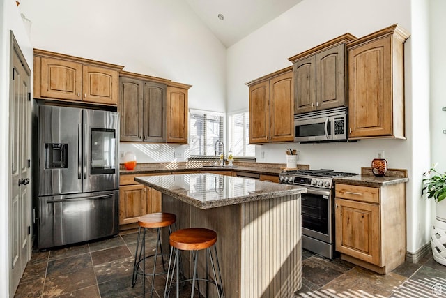 2652 E 6500 S, Uintah, UT 84403 - kitchen with stainless steel appliances, a sink, high vaulted ceiling, a kitchen island, and a breakfast bar