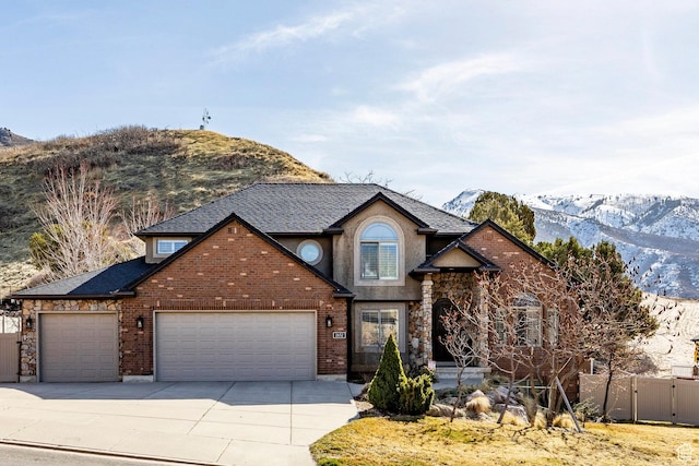 2652 E 6500 S, Uintah, UT 84403 - traditional-style home with an attached garage, a mountain view, concrete driveway, fence, and a gate