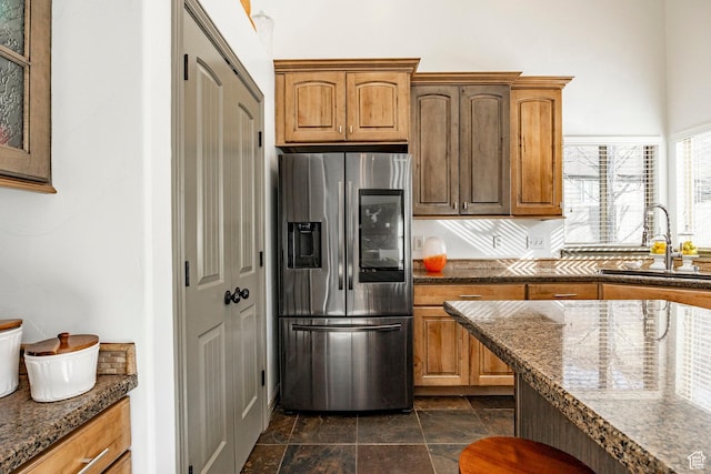 2652 E 6500 S, Uintah, UT 84403 - kitchen featuring stainless steel fridge, a sink, dark stone finish floors, dark stone counters, and brown cabinetry