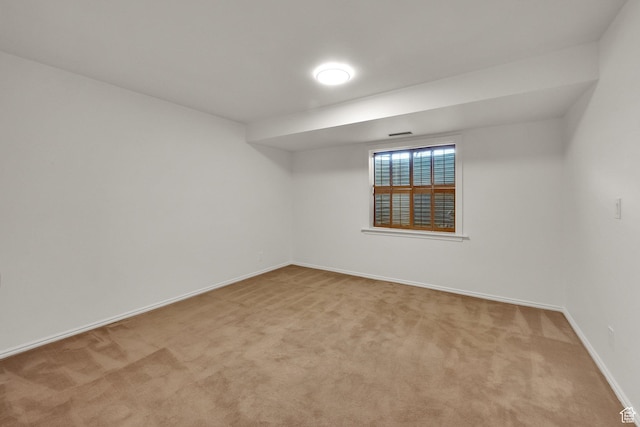 carpeted spare room featuring baseboards