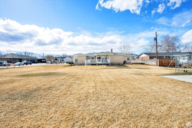 view of front of home featuring a residential view, a deck, a front lawn, and fence