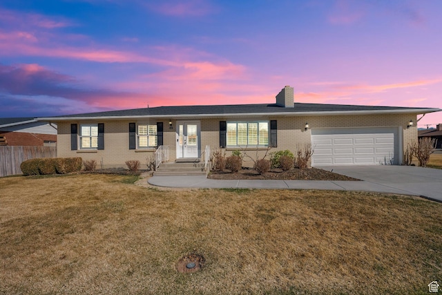 ranch-style house with fence, driveway, a front lawn, a garage, and brick siding